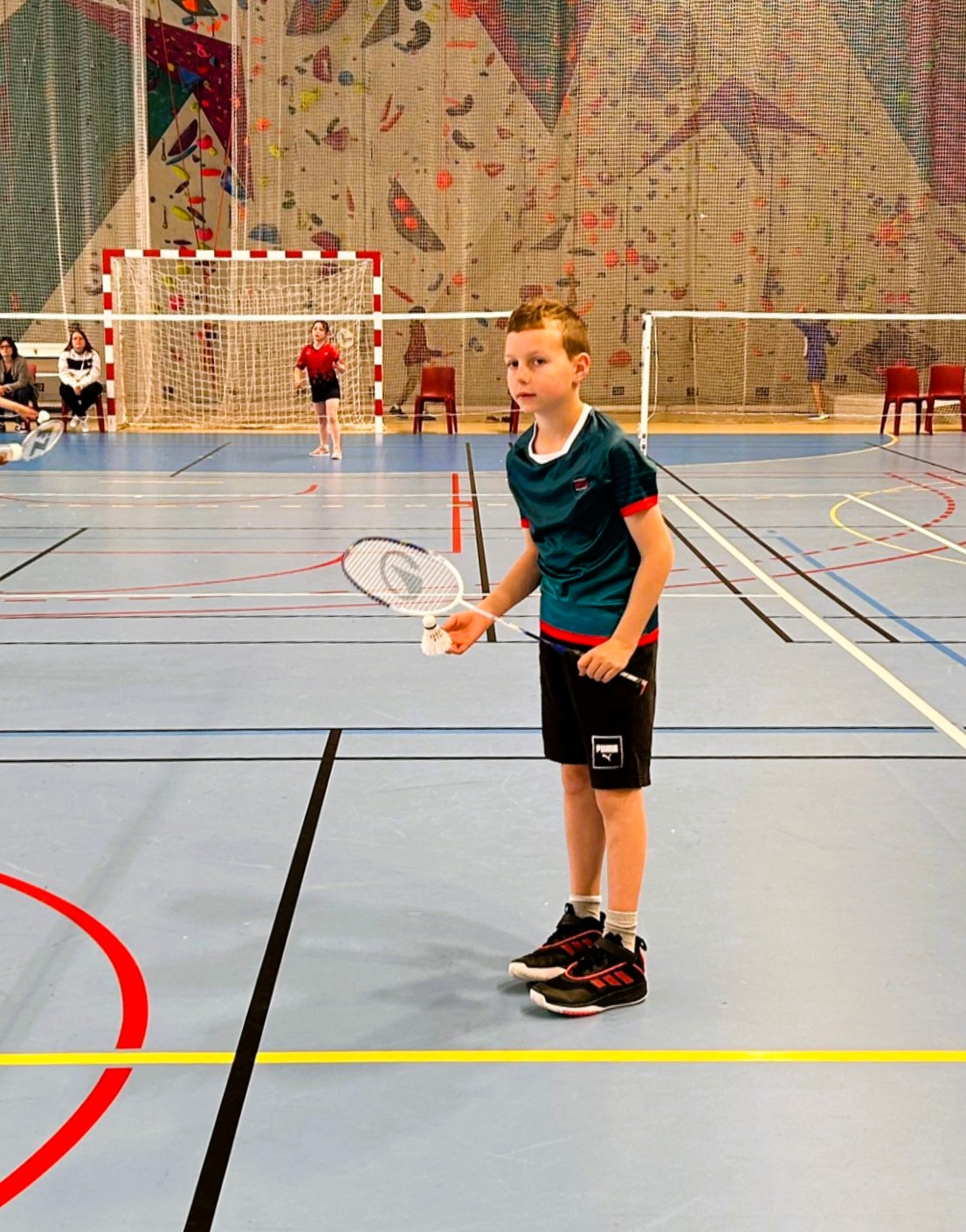 Jeune joueur avec sa raquette sur un terrain de badminton